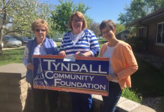 Donate to a Local Foundation: Tyndall CF sign held by ladies